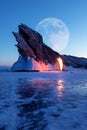 Winter Siberian landscape. Lake baikal, fire and ice on the background of the rock and the moon. Lake Baikal.