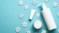 Winter skin care cosmetic products on blue background with snowflakes. Beauty products packaging design template. Moisturizer Royalty Free Stock Photo