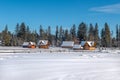 winter, a small village, wooden houses and the beautiful forests in the background Royalty Free Stock Photo
