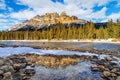 Winter snow along the banks of the Bow River in Banff with snow-melted puddle reflection of majestic Castle Mountain Royalty Free Stock Photo