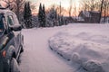 Winter snow blankets driveway and vehicle on a quiet morning at dawn