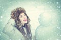 Winter snow blue toned. Joyful Beauty young woman Having Fun with snowman in Winter Park. Funny snowmen. Happy smiling Royalty Free Stock Photo