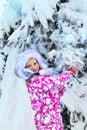 Winter with snow for child girl in clothes near tree in park. Royalty Free Stock Photo