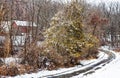 Winter snow on curving driveway leading to red barn