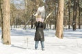 Winter snow fight happy girl throwing snow playing outside. Joyous young woman having fun in nature forest park on snowy day weari