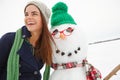 Winter, snow and happy woman hugging a snowman on Christmas outside in England smiling. Holiday, festive season and xmas Royalty Free Stock Photo