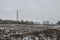 Winter snow on heather moorland, bare trees in distance and pylons / electricity wires Royalty Free Stock Photo