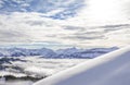 Snow covered mountains with inversion valley fog and trees shrouded in mist. Scenic snowy winter landscape in Alps at