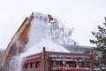 Snow removal on the streets. Close-up of falling snowballs from a snowplow and into a truck body. Municipal urban road maintenance Royalty Free Stock Photo