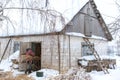 Winter is snowing. A male farmer carries dry reeds in a barn. Rural landscape Royalty Free Stock Photo