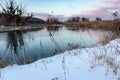 Winter snowy close-up on cold sunset river shore