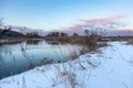 Winter snowy close-up on cold sunset river shore