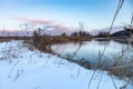 Winter snowy close-up on cold sunset river shore