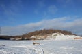 Winter snowy coastal landscape on a sunny day. Frozen river. Clear sky. Open space. Two boats on the shore