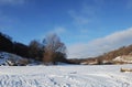 Winter snowy coastal landscape on a sunny day. Frozen river. Clear sky. Open space. Two boats on the shore