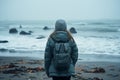 Winter solitude Girl in down jacket stands on seashore contemplating