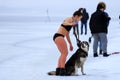 Winter sport, hardening in winter. A girl in a bathing suit with a dog stands near a river covered with ice and snow. Orthodox