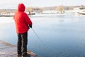 Winter, spring fishing on paid snow covered ice pond, lake in country club. Catching fish with spinner,bait, net.Fisherman with