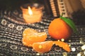 Winter still life with tangerines, mandarin slices on knitted sweater background with garlad cozy bokeh, copy space Royalty Free Stock Photo