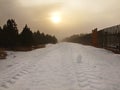 Winter stormy weather in mountains, dark snowy clouds, cold snow in the sky. The road covered by snow and ice. Slipper asphalt Royalty Free Stock Photo