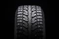 Winter studded tire for snow and ice. directional tread pattern. close-up on a black background, close-up Royalty Free Stock Photo