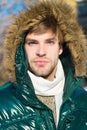 Winter stylish menswear. Winter outfit. Man unshaven wear warm jacket with fur snowy nature background. Guy wear winter