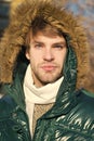 Winter stylish menswear. Winter outfit. Man unshaven wear warm jacket with fur snowy nature background. Guy wear winter