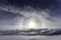 Winter Sun halo is above wild subarctic Scandinavian Mountains, very cold day with clear blue sky, some clouds and old chemtrails Royalty Free Stock Photo