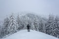 Winter sunrise. Man stays on the lawn covered with snow there is a trodden path leading to the forest. High mountain. Snowy Royalty Free Stock Photo