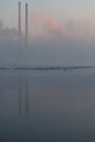 Winter sunrise over the lagoon with a view of the power plant immersed in fog