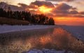 Winter sunset on a frozen lake with a reflection on the ice. Royalty Free Stock Photo