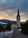 Winter sunset landscape of an old austrian church in an alps village, snowy mountains, Wallfahrtskirche Maria Schnee Matzelsdorf