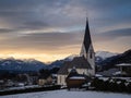 Winter sunset landscape of an old austrian church in an alps village, snowy mountains, Wallfahrtskirche Maria Schnee Matzelsdorf