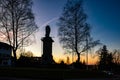 Winter sunset with silhouetted statue and trees