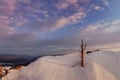Winter sunset on the top of the mountain a lot of snow and tree trunks painted sky with clouds