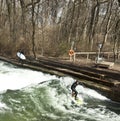 Winter surfing in diving suit on the Eisbach river at Englische