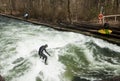 Winter surfing in diving suit on the Eisbach river at Englische