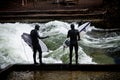 Winter surfing in diving suit on the Eisbach river at Englische