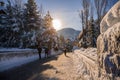 A winter tale - a sunny day for Christmas. Snow-covered streets, houses, sun rays, people walking along the pedestrian zone. ski