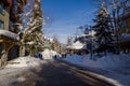 A winter tale - a sunny day for Christmas. Snow-covered streets, houses, sun rays, people walking along the pedestrian zone. ski