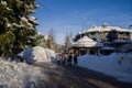 A winter tale - a sunny day for Christmas. Snow-covered streets, houses, sun rays, people walking along the pedestrian zone. ski