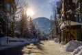 A winter tale - a sunny day for Christmas. Snow-covered streets, houses, sun rays, people walking along the pedestrian zone. ski