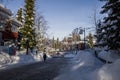 A winter tale - a sunny day for Christmas. Snow-covered streets, houses, sun rays, people walking along the pedestrian zone. ski