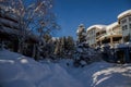 A winter tale - a sunny day for Christmas. Snow-covered streets, houses, sun rays, people walking along the pedestrian zone. ski