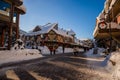 A winter tale - a sunny day for Christmas. Snow-covered streets, houses, sun rays, people walking along the pedestrian zone. ski