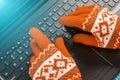 Winter time - computer keyboard hands in warm gloves work at the computer, workplace in winter Royalty Free Stock Photo