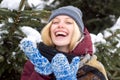 Winter time. Happy cute girl in winter knitted hat sending blowing a kiss air. Outdoor shot of a happy blonde woman Royalty Free Stock Photo