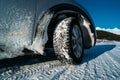 Winter tire. Car on snow road. Tires on snowy highway detail. Royalty Free Stock Photo