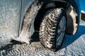 Winter tire. Car on snow road. Tires on snowy highway detail. Royalty Free Stock Photo