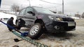 Winter tire fitting on the street. Wheel service, Tire repair, and changing summer to studded winter tires. Black car lifted on